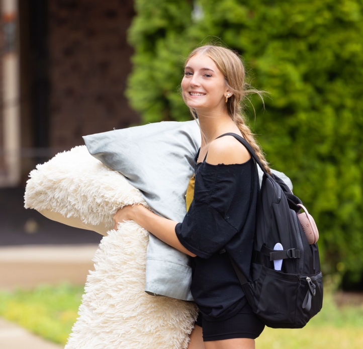 Student carrying pillows
